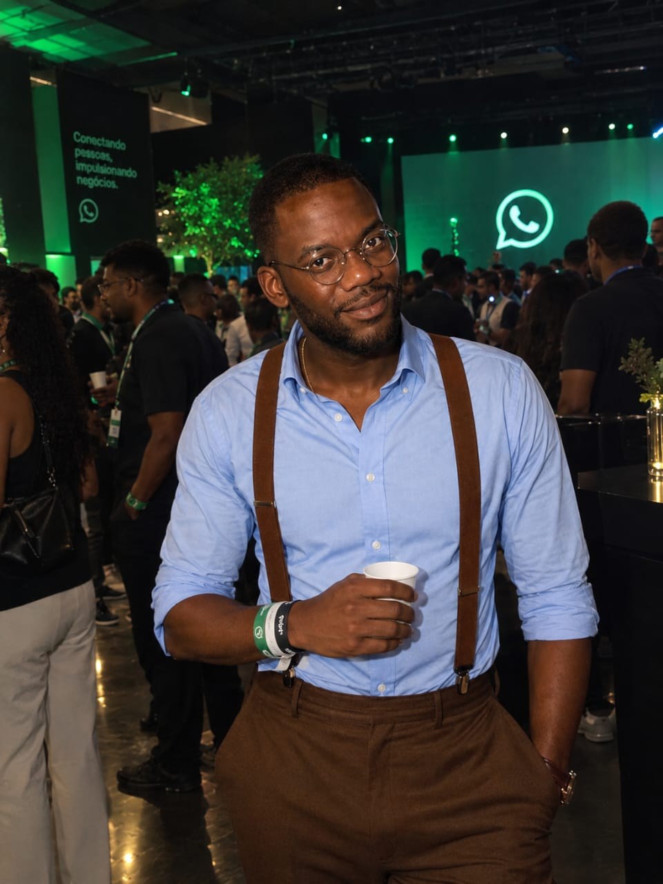 Retrato do fundador do WatSeller, de camisa azul e suspensórios castanhos, num evento do WhatsApp